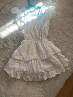 Meet me there klänning  - Söt vit omlottklänning med volanger och kort ärm från meet me there använd få gånger 