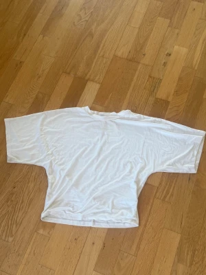 Vit oversized t-shirt - En basic vit oversize passform T-shirten är  figursydd i midjan och har korta utsvängda armar är från lager 157. 