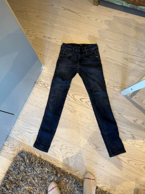Mörkblå skinny jeans från Replay - Snygga mörkblå skinny jeans från Replay med klassisk femficksdesign och låg midja. Jeansen har diskreta slitningar och är tillverkade i stretchigt denimtyg för en bekväm passform. Perfekta till en avslappnad streetstyle-look.