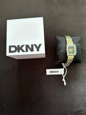 DKNY damklocka - Ursnygga klocka från DKNY. Modell: Westside Glitz Grön/Guldtonat stål.  Oanvänd och fortfarande plomberad. ca-Mått: 30x22 mm Ref: DK5L008M0085. Perfekt som studentgåva. 