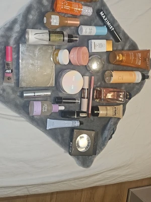 Stort kit med basprodukter smink & hudvård - Säljer ett stort kit med basprodukter inom smink och hudvård. Innehåller foundation, primer, ansiktskräm, serum, settingspray, highlighter, lösfransar och palett från märken som Glow Recipe, e.l.f., COSRX, Drunk Elephant och fler. Färgerna går i neutrala och ljusa toner. Perfekt för dig som vill testa olika produkter.