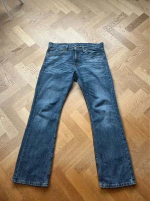 Levis 527 - Klassiska blå jeans från Levi's med rak passform och fem fickor. Jeansen har en snygg tvättad look och är tillverkade i slitstark denim. Perfekta för en avslappnad stil och passar till det mesta i garderoben.