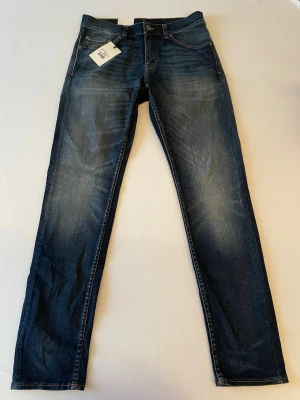 Mörkblå jeans från Tiger Of Sweden (oanvända) - Snygga mörkblå jeans med tvättade detaljer och klassisk femficksmodell. Modellen är Evolve och har slight drop och slim fit. Oanvända med etiketten kvar. Nypris 1699. 