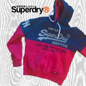 Sällsynt Superdry Vintage Hoodie - En supersnygg Superdry hoodie i stil inspirerad från japansk vintage. Mycket populär typ av tröja just nu, och dessutom i en riktigt snygg modell och färg🤩Etiketten visar stl S och den passar även därefter. Tröjan sitter supersnyggt och är helt utan fläckar med tyg i superfint skick👌vi luvöppningen finns en ytterst liten defekt som inte är märkvärdig vid användning. Det som hänt är att en tråd gått av just där👈Syns på bild 3 och 4👍 Tröjan passar superbra på personer mellan 170-176 cm.