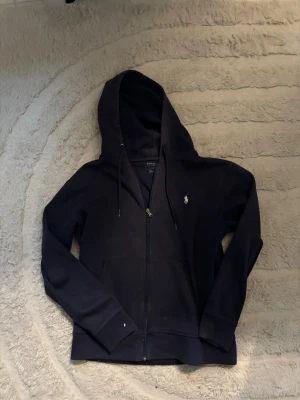 Mörkblå hoodie från Polo Ralph Lauren - Mörkblå hoodie med dragkedja från Polo Ralph Lauren. 