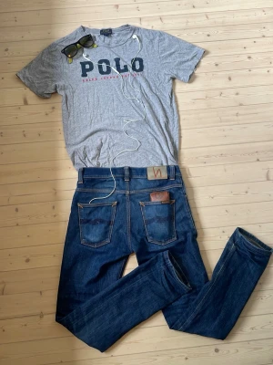 Ralph Lauren T-shirt  - Säljer en grå t-shirt från Polo Ralph Lauren med stort tryck på bröstet. T-shirten är i strl L barn som på bilden och passar enligt lappen 14-16 år. Hör gärna av er om ni har några frågor! MVH tom.