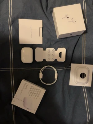 AirPods pro 2 - Säljer ett par vita Apple AirPods Pro med trådlöst laddningsetui. Hörlurarna är i klassisk Apple-design och levereras med extra silikontoppar och laddningskabel. Perfekta för musik, samtal och träning tack vare brusreducering och smidig passform.