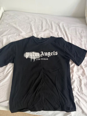 Svart Palm Angels t-shirt - Säljer en svart t-shirt från Palm Angels med trycket 'Palm Angels LAS VEGAS' i vitt framtill. T-shirten har korta ärmar och en klassisk passform. Perfekt för dig som gillar streetwear och vill ha något stilrent men ändå med attityd.   Pris kan diskuteras 