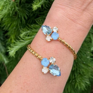 Mixed sized armband Bangle  - Mixed Sized Armband, i guldpläterad mässing med kristaller. Ss 29 6mm, ss39 8mm och Pear 14mm. Färg Light Sapphire, Clear Crystal, Linnen Ignite och Sky Ignite. Ställbar storlek. De sista bilderna visar andra färger och modeller som finns i lager.  Jag skickar endast spårbart, samfraktar. Fast pris. Besök gärna mina övriga annonser.  Till mina smycken använder jag kristaller från Preciosa, Aurora och Swarowski.