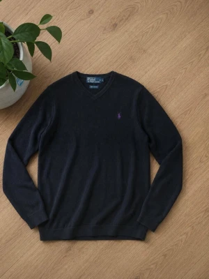Svart V-ringad tröja från Polo Ralph Lauren - KÖP INTE ÄR BORTREST Klassisk svart V-ringad tröja från Polo Ralph Lauren med lila broderad logga på bröstet. Tröjan har långa ärmar och är tillverkad i mjukt material som passar perfekt till en stilren look.