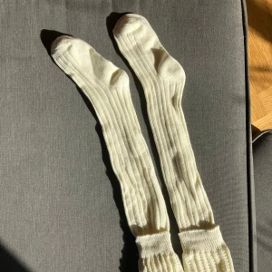 Långa ribbade vita ullstrumpor - Säljer ett par långa, ribbade over knee-strumpor i mjuk vit ull. De är endast provade. Ca 63 cm långa och passar runt +- stl 38.