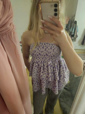 Ljuslila blommig volang topp/kjol - Jag säljer en supersöt kort sommarkjol från Gina Tricot i storlek XS som både kan användas som kjol och topp. Den är ljuslila med små lila blommor med volanger. Den är en perfekt till sommaren. Nypris runt 300 kr. I mycket bra skick och använd fåtal gånger.