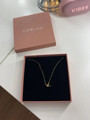Guldhalsband med fågel från Edblad - Halsband från Edblad med ett hängsmycke i form av en fågel. Kommer i original ask. Helt oanvänd! 