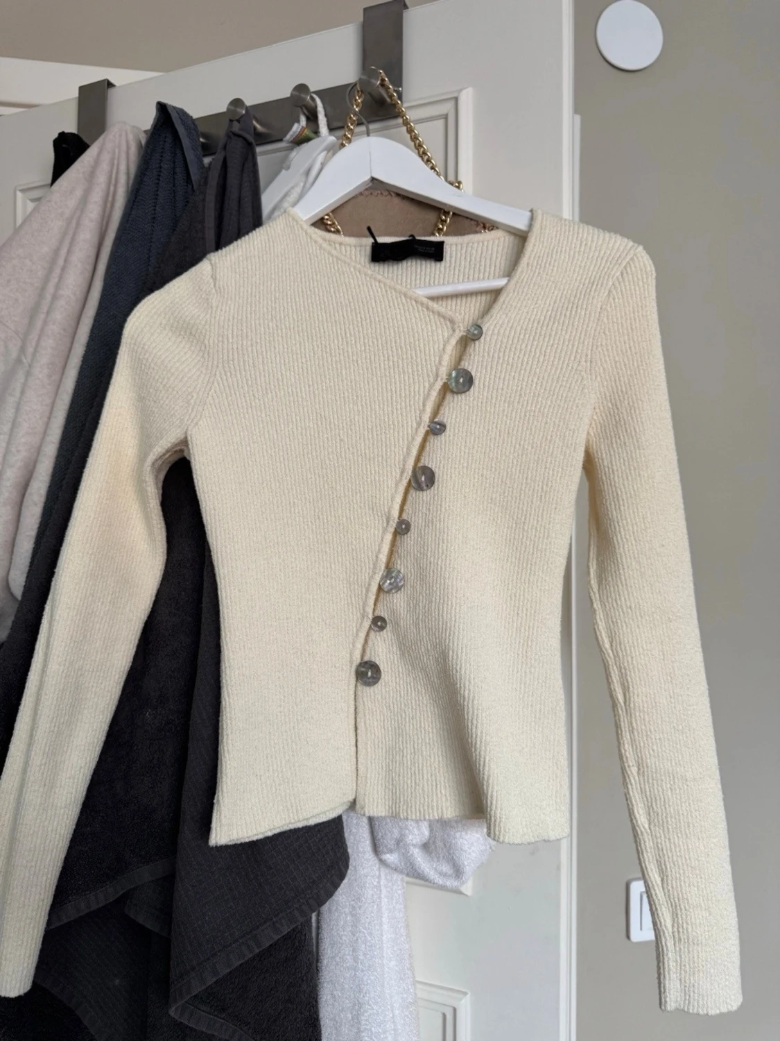 Krämvit stickad cardigan med sned knäppning
