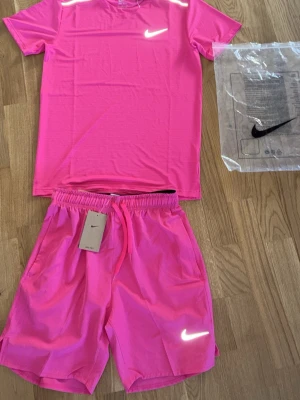 Nike set  - Nike set, storlek M, färg Rosa, Lyser i mörkret. Aldrig använd ettiket och påse tillkommer. Den är aldrig använd och är i perfekt skick för dig som bär storlek S/M. Väldigt efterfrågad nu till sommaren. Köp innan den säljs. Skickar samma dag eller dagen efter med snabba svar 