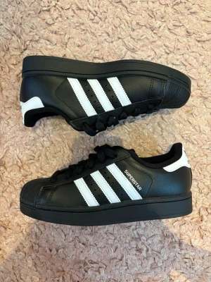 Adidas superstars - Helt nya oanvända adidas superstar i 37 1/2. Svarta och bra. Säljer eftersom jag köpte fel och kunde inte Skcika tillbaka dem vill helst bli av med dem så snabbt som möjligt köpa för 1200kr