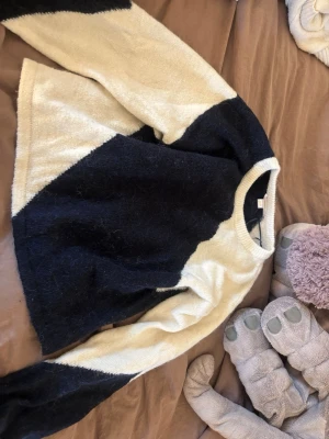 Stickad tröja Gina Tricot svart/vit - Säljer en snygg stickad tröja från Gina Tricot i svart och vitt. Tröjan har ett coolt diagonalt färgblocksmönster och är långärmad med rund hals. Perfekt för dig som gillar en avslappnad men trendig stil.