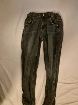 Svarta slim fit jeans med resårmidja - Snygga svarta slim fit jeans med resår i midjan och vita kontrastsömmar. Perfekta för en avslappnad och trendig look.