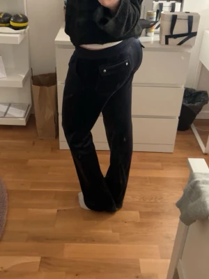 marinblå/svara juicy couture byxor. - Säljer ett par marinblå juicy byxor med snörning i midjan. Byxorna har fickor med knappdetaljer bak. Supermjuka och sköna att ha på sig.Säljer för dem inte kommer till användning. Köpta för 1100kr.