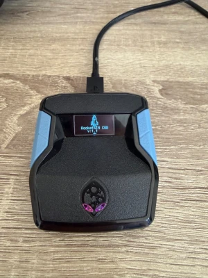 Cronus Zen handkontroll-adapter - Cronus Zen är en kompakt svart och blå adapter för spelkonsoler som PS4, Xbox One, Nintendo Switch, Xbox Series X|S, Xbox 360 och PS3. Med OLED-skärm och USB-anslutning kan du använda nästan vilken handkontroll som helst och få tillgång till funktioner som aim assist och turbo. Kommer med ett nedladdat script till black ops 7