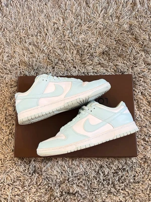 Nike Dunk low - Limited Edition - Kvalitétsneakers från Nike säljes i fint skick   En riktigt fin sommar sko. Bekväm passform med en stabil sula. Fick i present, säljes pga fel storlek tyvärr. Använda en gång så väldigt fint skick (precis som på bilder). Påminner om Air force, men något lättare, luftigare, ”Air” och lika stabil sula.   Mint Condition Färg Glacier Blue Skorna är storlek 44 US 10 Originalbox saknas Retail ligger mellan 1300-2600kr