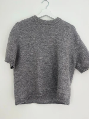 Grå stickad t-shirt från Gina Tricot - Kortärmad stickad t-shirt i mjuk grå från Gina Tricot. 