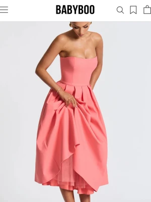 Rosa axelbandslös klänning Babyboo - Lappen är på, endast testad😊💕🌟✨priset kan diskuteras vid snabbköp 🔥Axelbandslös rosa klänning från Babyboo med figurnära överdel och utsvängd kjol med veck. Klänningen har en elegant siluett och är tillverkad i ett slätt material som ger ett lyxigt intryck. Perfekt för dig som vill ha en feminin och trendig look. 