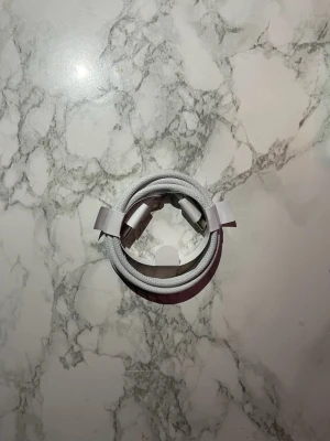 27 Stycken USB-C laddningskabel 60W 1m vit - Säljer en vit USB-C till USB-C laddningskabel på 1 meter, perfekt för snabbladdning av mobiltelefoner och andra enheter. Kabeln är flätad för extra hållbarhet och har en stilren design. Kommer i originalförpackning.