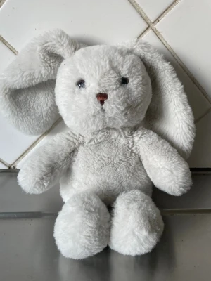 Vit mjuk kanin från Teddykompaniet - Supermjuk och fluffig vit kanin från Teddykompaniet med långa öron och broderad nos. Perfekt som gosedjur eller present till någon som gillar söta mjukdjur.    Cs 30 cm lång Tillverkad i mjukt plyschmaterial.