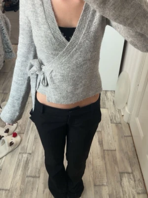 Stickad kofta med knyte - En stickad kofta/topp i XS som man knyter, från Gina Tricot som är använd 1-3 gånger. Den är i jättefint skick och har inga fläckar och den märks knappast att den har varit använd 1-3 gånger.