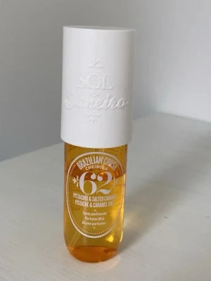 Sol de Janeiro Brazilian Crush 62 - Sol de Janeiro Brazilian Crush Cheirosa 62 är en parfymmist med doft av pistage och saltad karamell. Flaskan är genomskinlig med guldfärgad vätska och har ett stort vitt lock med präglad logga. Perfekt för dig som gillar söta och unika dofter.