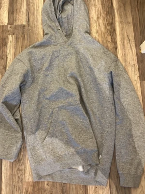 Grå  hoodie  - Enkel och stilren grå hoodie som är helt ny. Säljer då den är för stor för mig. Skulle säga att storleken är mellan S och M.