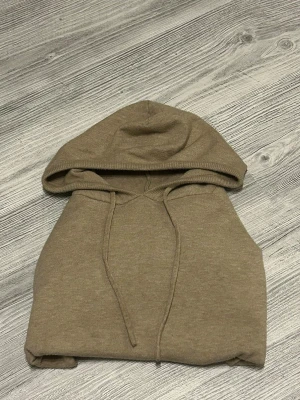 Kashmir hoodie  - En stilren beige kashmir hoodie med klassisk huva och snörning framtill. Hoodien har en enkel design utan tryck eller mönster och är tillverkad i ett mjukt material som känns skönt mot huden. Perfekt för en avslappnad look. Passar om du är runt 164-170