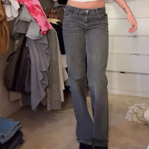 Grå raka jeans med hög midja - Säljer ett par grå jeans med rak passform och hög midja. Jeansen har klassisk femficksdesign och stängs med knapp och dragkedja. Perfekta för en avslappnad och trendig look.