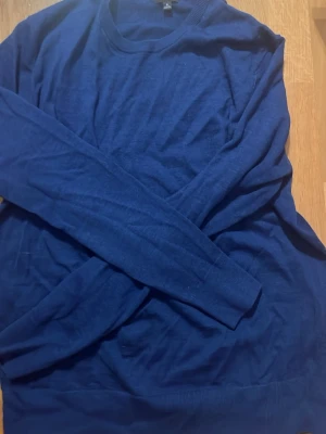 Mörkblå stickad tröja - En enkel och stilren mörkblå stickad tröja med rund halsringning. Ett grymt basplagg, typ oanvänd och sticks inte alls. 100% ull. Inga defekter