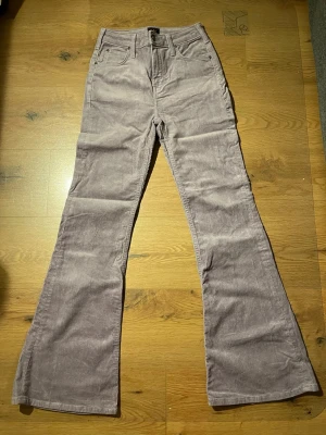 Ljuslila utsvängda manchesterbyxor Lee - Säljer ett par ljuslila manchesterbyxor från Lee med utsvängda ben och klassisk femficksdesign. Byxorna har hällor för skärp och stängs med knapp och dragkedja. Perfekta för dig som gillar retrostil och vill sticka ut lite extra.