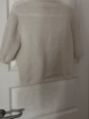 Beige stickad tröja Gina Tricot - Mysig beige stickad polo tröja från Gina Tricot med kortare ärmar och rak passform. Tröjan är enkel och stilren, perfekt att matcha med jeans eller kjol. Materialet är mjukt och ger en avslappnad look. Den är använd 1 gång men gillar inte passformen. Den är i storlek 164-170