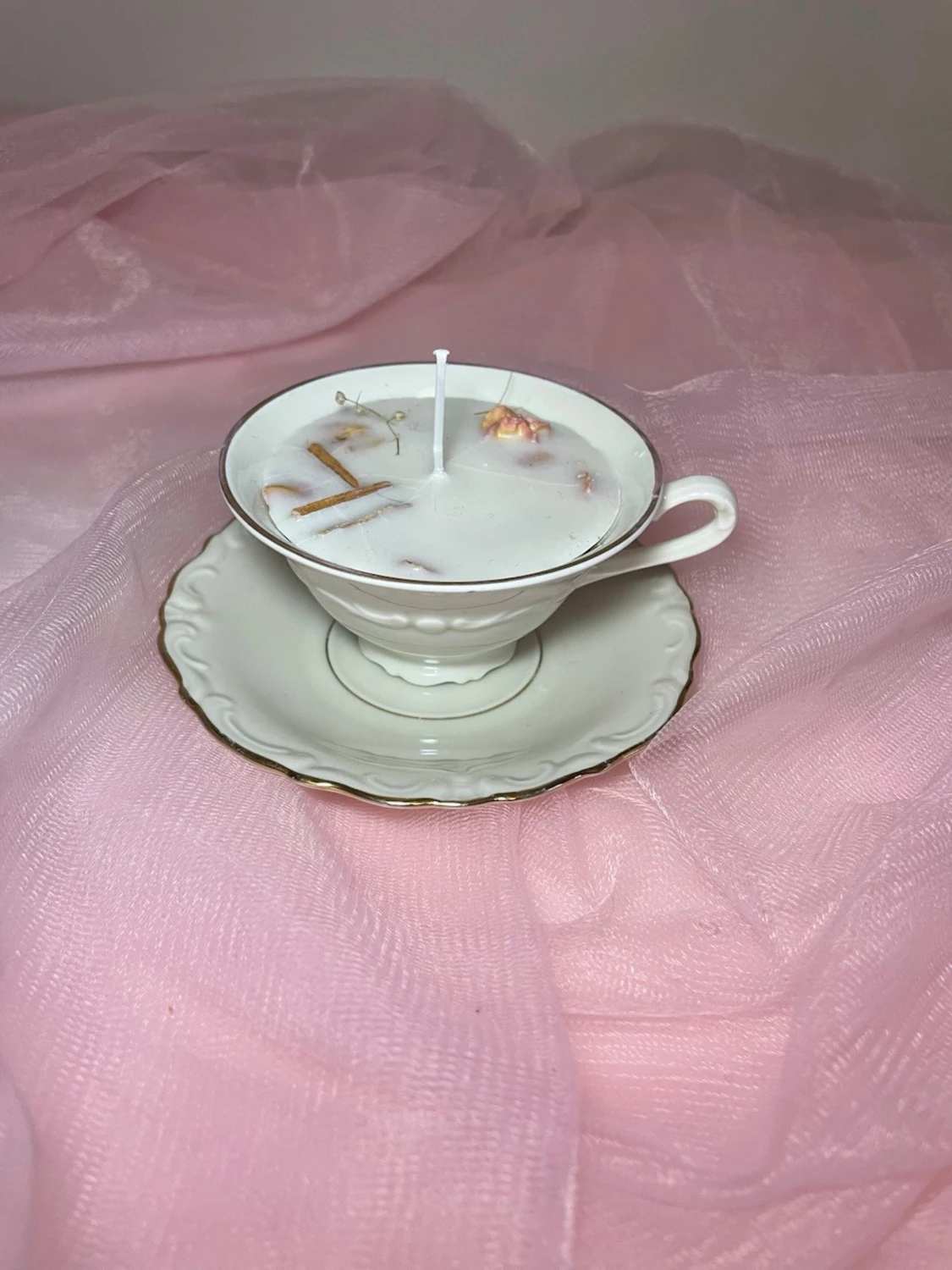 Doftljus i en tekopp i en vit färg med torkade blommor och kanel  - 2