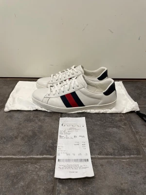 Gucci Ace skor - Feta Gucci Ace skor. Storlek 8 1/2 uk motsvarar 42,5. De är repainted på sidan av sulan (se bild 5) annars väldigt bra skick. Kvitto och dustbag medkommer. Pris kan självklart diskuteras!!