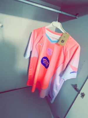 🔥 FC Barcelona matchtröja – Original Nike  - Säljer en äkta FC Barcelona T-shirt/matchtröja från Nike i den snygga rosa bortatröjan med Spotify-loggan. Modern design som sticker ut – perfekt för både match, träning eller streetwear.  ✔ 100 % original (Nike-tag kvar) ✔ Officiell FC Barcelona-tröja ✔ Lätt och ventilerande material ✔ Färg: Rosa/vit ✔ Skick: Mycket fint / nyskick  💰 Ordinarie nypris: ca 1 000–1 100 kr i butik ➡️ Perfekt chans att göra ett kap!  