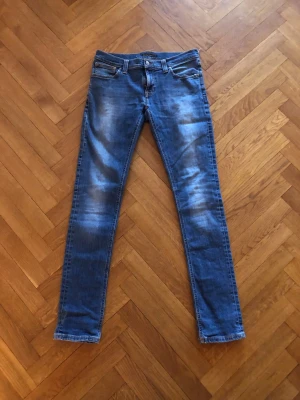 Nudie Jeans - Säljer ett par blå Nudie jeans med riktigt najs tvätt. Skicket är 10/10 men priset bara 500kr