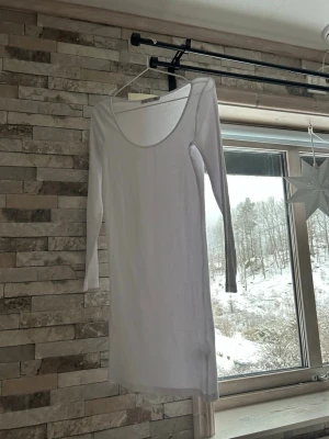 Vit ribbad långklänning 157 - Säljer en enkel och stilren vit ribbad klänning från 157 i storlek S.  har lång ärm och rundad urringning, tillverkad i mjukt och stretchigt material 