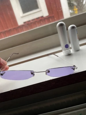Solglasögon, Slim Shady’s by Christianah Jones - Trendiga smala design-glasögon med lila glas och tunn metallbåge. Kommer med ett silvrigt etui. Kvalité, design, som nya.