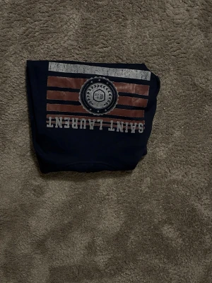 Yves saint Laurent Hoodie - Säljer en snygg Saint Laurent hoodie som jag fick av min kusin. Använd väldigt lite, i mycket fint skick. Originaltaggar finns kvar (se bilder). Storlek M passar s. Bara att hojta till om det är något. Byte är möjligt