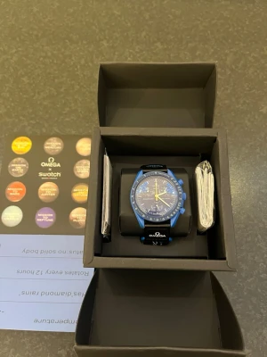 Omega x Swatch Mission to Neptune - Säljer en Omega x Swatch Speedmaster Mission to Neptune med blå boett och blå urtavla och svart kardborreband. Säljer pågrund av att klockan ej passade mig därav alldrig andvänd och skyddsplast fortfarande på.