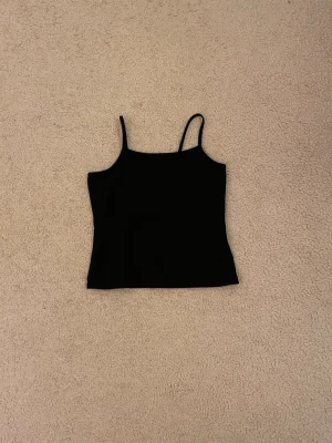 Svart linne från Lindex  - Säljer ett kort svart linne med smala axelband.🩷