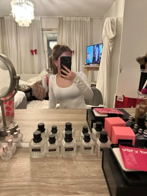 Vit långärmad topp med rund hals - Säljer en stilren vit långärmad topp med rundad halsringning. Toppen har en tight passform och är perfekt att matcha med jeans eller kjol. Enkel och clean design som funkar till många olika looks.