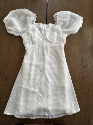 Vit kort klänning med puffärmar - Superfin vit kort klänning från Missguided med puffiga kortärmar och diskret prickigt mönster. Perfekt som studentklänning. Storlek 36