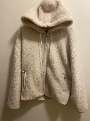 Beige teddyjacka med huva från Oysho - Säljer vår Doona med isofixbas, bilsätesskydd ingår. Är i mkt bra skick. Pris kan diskuteras vid snabb affär. Säljer vår Doona med isofixbas, bilsätesskydd ingår. Är i mkt bra skick. Pris kan diskuteras vid snabb affär. Säljer vår Doona med isofixbas, bilsätesskydd ingår. Är i mkt bra skick. Pris kan diskuteras vid snabb affär.  beige teddyjacka från Oysho i storlek L. Jackan har stor huva, dragkedja framtill, två fickor med dragkedja och detaljer i syntetmaterial runt fickorna. Perfekt för kall