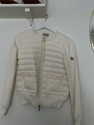 Vit quiltad jacka från Moncler - Säljer en stilren vit cardigan från moncler i storleken S, perfekt för dig som gillar stil och som vill stila ut, helt ny postar snabbt och kan gå ner i pris vid snabba köp